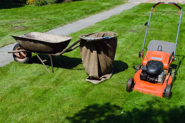 Mower and wheelbarrow to throw the grass — Stock Photo, Image