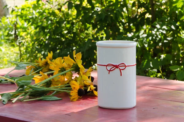 Flores de rudbekia encontram-se mesa de madeira perto vaso branco — Fotografia de Stock