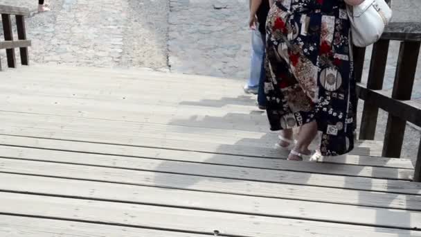 Туристи спускаються по сходах дерев'яними сходами старого замку — стокове відео