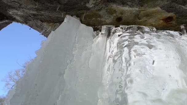 Fat ice piece frozen stream water flow under waterfall closeup — Stock Video