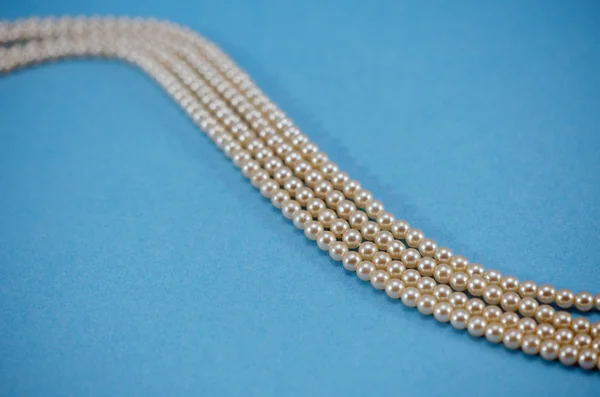 Pearl necklace collar bead closeup blue background — Stock Photo, Image