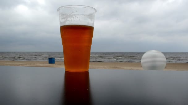 Пластиковий кухоль пиво підставка пляжний паб стіл фон море — стокове відео