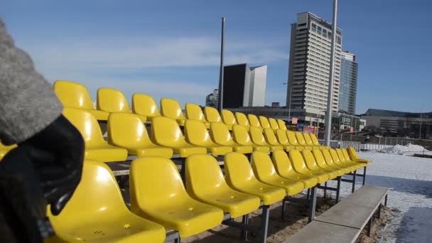 Vrouw gaat langs de rij gele stoelen volleybal in de winter — Stockvideo