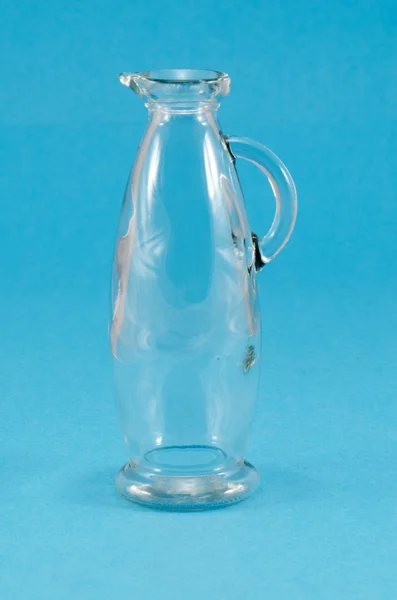 Old glass jug jar pitcher handle on blue — Stock Photo, Image