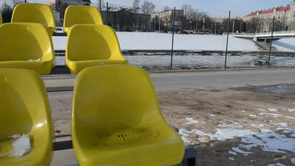 Cadeiras amarelas e gelo flutuante no rio nos primeiros dias primavera — Vídeo de Stock