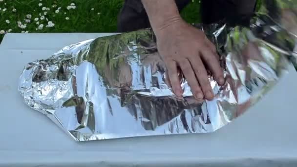 Fast hands wrap big fish into foil for baking in fire ember — Stock Video