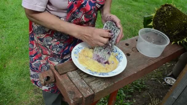 Äldre kvinna rivjärn shredder potatis — Stockvideo