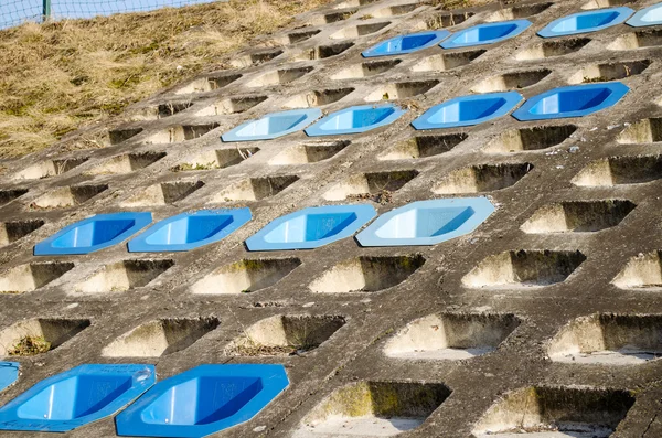 Cement utanpåliggande lutning fyra rad blå stolar — Stockfoto