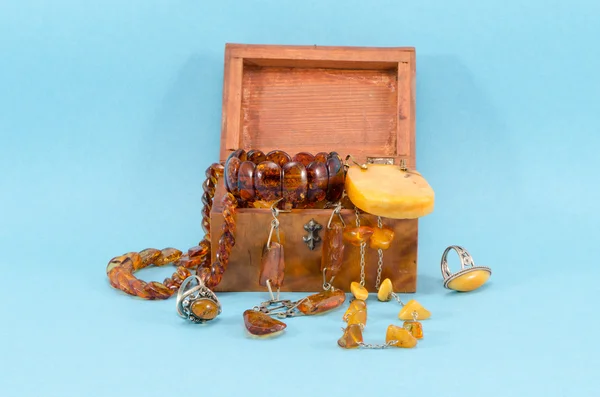 Bursztyn biżuteria kamień retro drewniane pudełko na niebiesko — Zdjęcie stockowe