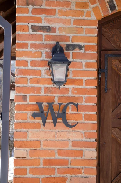 Wc toilet sign symbol red brick wall retro lamp — Stock Photo, Image