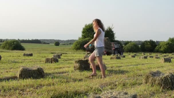 Kvinna bära bale traktor — Stockvideo
