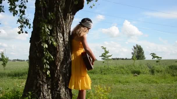 Dziewczynka gra gitara drzewo — Wideo stockowe