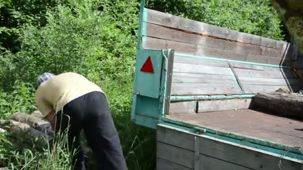 Hombre carga registro madera remolque — Vídeos de Stock