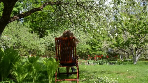 Mujer silla relax jardín — Vídeos de Stock