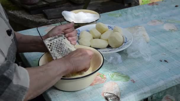 Old woman grater potato — Stock Video