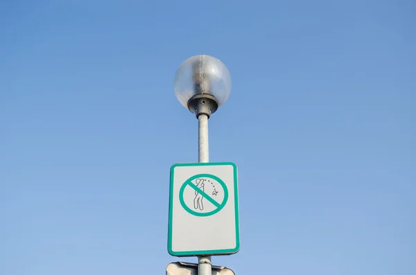 Warning sign on littering streets on street lamp — Stock Photo, Image