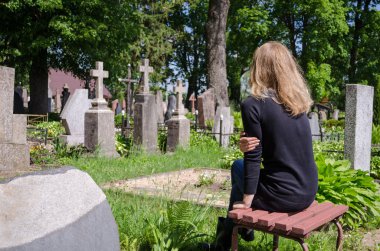 Sorrow woman near father husband tomb in cemetery  clipart