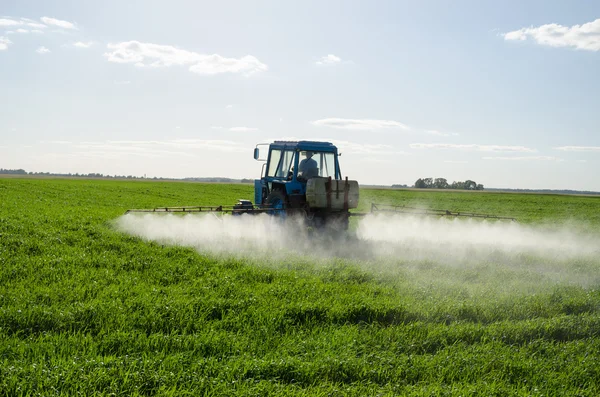 Traktor sprej zúrodnit pole pesticidů, chemických — Stock fotografie