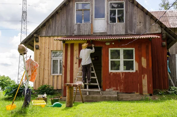 Painter man on ladder paint old wooden house — Stock Photo, Image