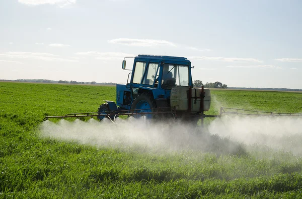 Tractor fertilize field pesticide and insecticide — Stock Photo, Image