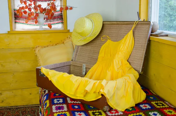 Maleta abierta con vestido amarillo paja sombrero femenino — Foto de Stock