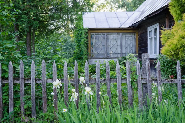 Altes Landhaus mit Veranda und rustikalem Holzzaun lizenzfreie Stockfotos