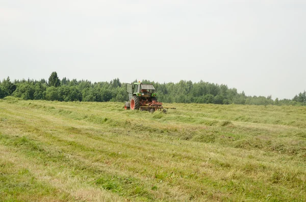 Pole práce zařízení traktor seno třepačce práce — Stock fotografie