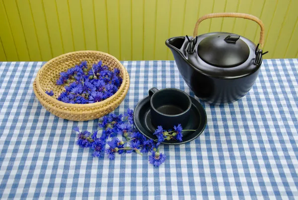 Freshly picked cornflower on basket clay tea set — Stock Photo, Image