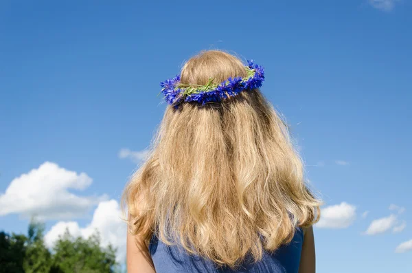 Mulher ondulado cabelo e coroa de flores no fundo do céu — Fotografia de Stock