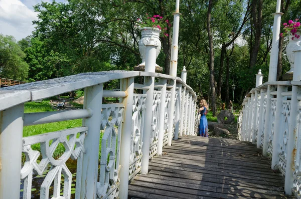 Brücke wackelt Geländer und Mädchen ruht sich an Brücke aus — Stockfoto