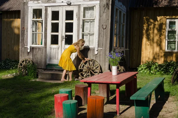 Casa rurale cortile e ragazza rotolo vecchia ruota carrozza — Foto Stock