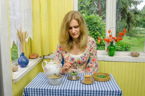 Mädchen bereiten Kräuter-Minze-Melisse-Blatt-Tee in Retro-Tasse zu — Stockfoto