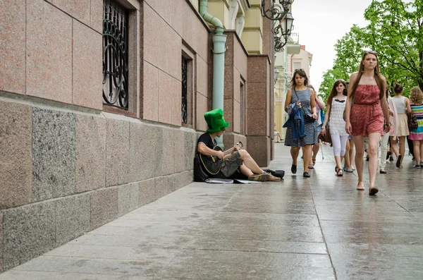 Μουσικός του δρόμου πράσινο καπέλο παιχνίδι δρόμο με κιθάρα — Φωτογραφία Αρχείου