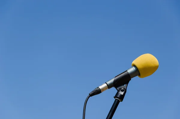 Желтый микрофон голубое небо bakcground — стоковое фото