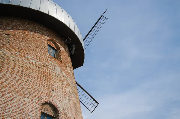 Kant van rustieke molen met venster op hemelachtergrond — Stockfoto