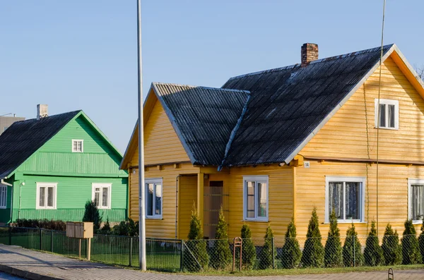 Rural verde amarillo pintado casas a lo largo de la calle —  Fotos de Stock