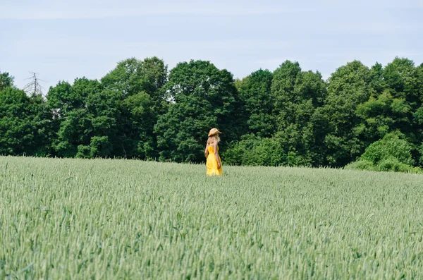 Farmer woman in yellow dress walk wheat field — Stock Photo, Image