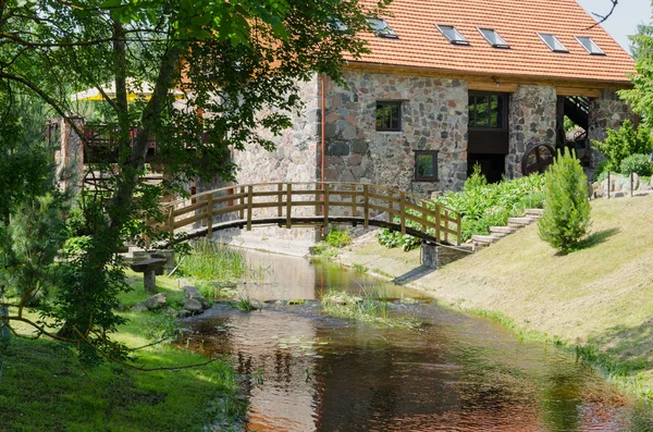 Park mit Brücke über Bach altes Backsteinhaus — Stockfoto