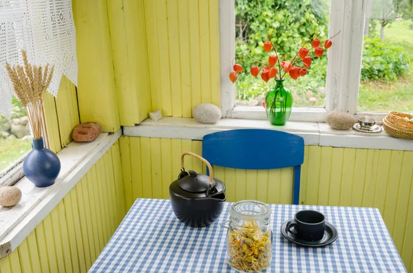 农村的房间和桌子上的陶瓷茶具金盏菊 图库图片