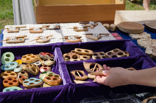 Hand takes wooden decorative buttons sold in fair — Stock Photo, Image