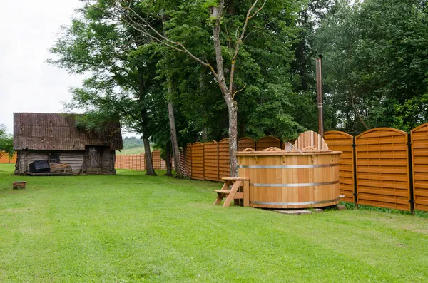 Jacuzzi de madera agua patio rural. placer al aire libre . Fotos de stock