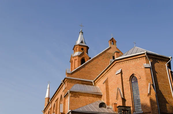Gotiska kyrkan står hög kors på blå himmel bakgrund — Stockfoto