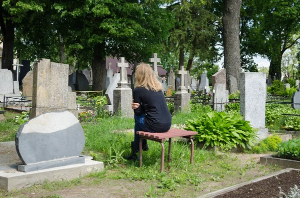 悲伤的女人缩在父亲的丈夫坟附近 — 图库照片