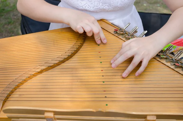 Ancient stringed baltic psaltery and girls hands — Stock Photo, Image