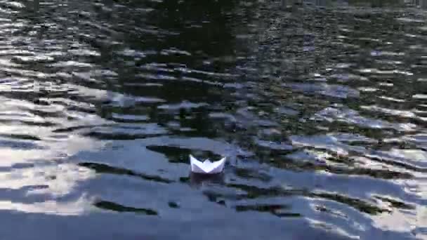 Liten origami papper fartyg flyter på rippel flodvatten. Följ — Stockvideo