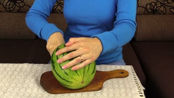 Hand schneidet Wassermelone kaum in zwei Teile und schneidet Scheibe auf Teller — Stockvideo