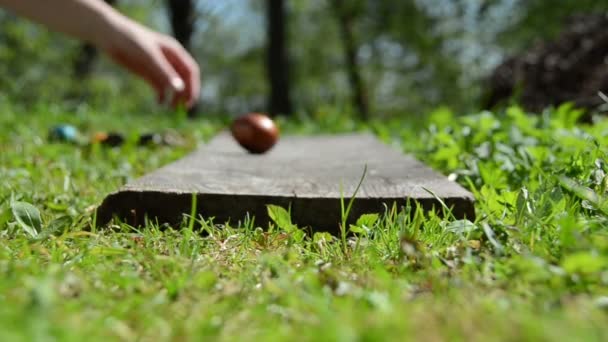 Hand roll painted eggs on wooden old board. Easter game. — Stock Video