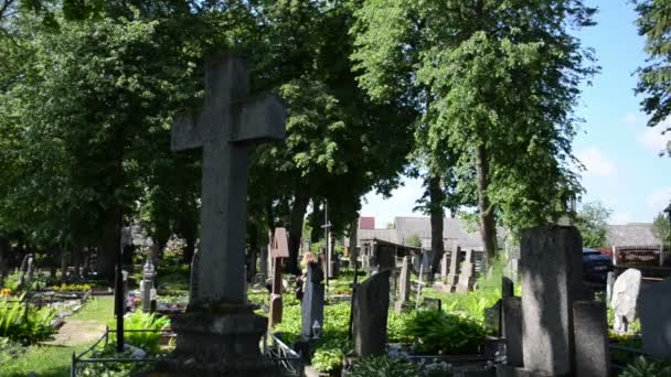 Женщины посещают близких людей на кладбище — стоковое видео