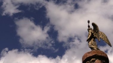 altın rengi melek heykeli elinde meşale ile. Mavi gökyüzü arka plan