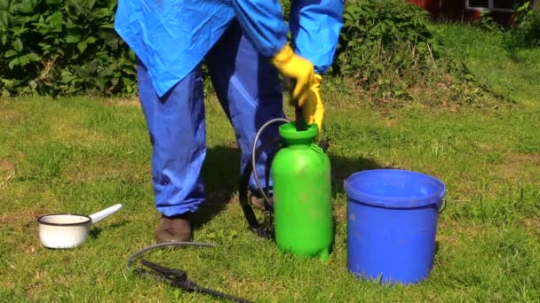 Handgemischter Dünger in Sprühgerät im grünen Hof. Arbeit im Garten. — Stockvideo